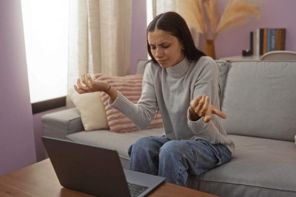 Confused Woman trying to figure out if the message she's received on her laptop is a Facebook phishing scam.
